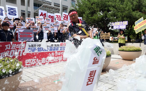 민주노총 대전본부 관계자가 3일 오전 대전시청 북문 앞에서 총파업 돌입 선언 기자회견을 하던 중 얼름 깨기 퍼포먼스를 벌이고 있다. 2023.7.3. 연합뉴스.