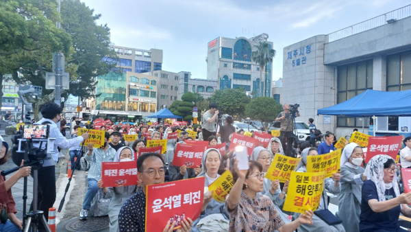 시국기도회에 참석한 수녀와 신도, 도민들이 ‘해양투기 결사반대’ 등의 팻말을 들고 구호를 외치고 있다. © 이봉수