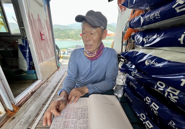 지난 6일 전남 여수시 돌산읍 군내리 돌산항 인근 해상 가두리양식장에서 박평운 씨(63)가 장부를 보여주고 있다. 지난해 비슷한 기간보다 10분의 1로 위탁판매고가 줄었다. 2023.7.11. 김성진 기자