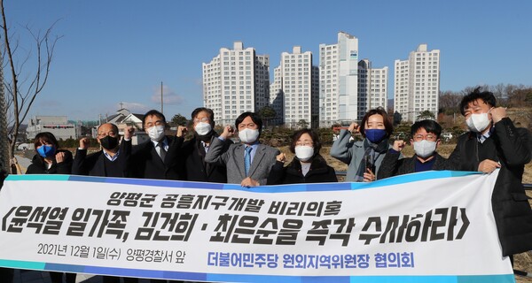 더불어민주당 원외위원장 협의회 소속 원외위원장들이 2021년 12월 1일 경기도 양평군 공흥지구 앞에서 '윤석열 처가의 양평 공흥지구 개발 특혜 의혹' 관련 수사를 촉구하는 구호를 외치고 있다. 뒷편에 보이는 아파트가 최은순 씨가 개발한 공흥지구 한신휴아파트. 2021.12.1. 연합뉴스