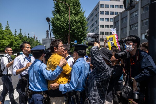 지난 10일 도쿄이 일본총리 관저 앞에서 후쿠시마 핵오염수 해양 투기 반대시위를 벌인 시민들이 경찰의 에스코트를 받고 있다. 2023.07.10. AFP 연합뉴스
