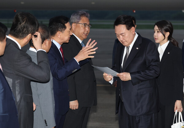 리투아니아에서 열린 북대서양조약기구(NATO·나토) 정상회의 참석과 폴란드·우크라이나 방문을 마친 윤석열 대통령이 17일 성남 서울공항을 통해 귀국, 국민의힘 김기현 대표가 준비한 수해 관련 자료를 살펴보며 대화하고 있다. 2023.7.17 연합뉴스