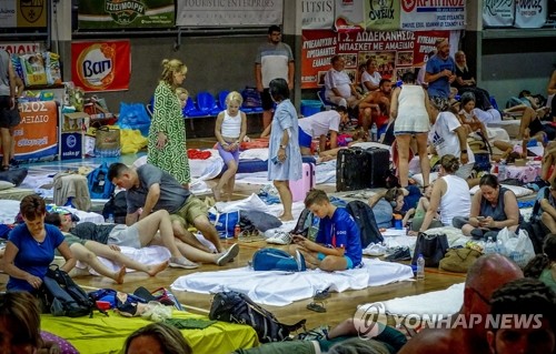 산불이 그리스 곳곳을 휩쓰는 가운데 23일(현지시간) 동남부 로도스섬에서 대피한 관광객들이 체육관에 모여 있다. 지난 18일 시작된 로도스섬 산불은 최근 그리스를 덮친 산불 중 가장 큰 규모로 기록되고 있다. 2023.07.24. 로이터 연합뉴스