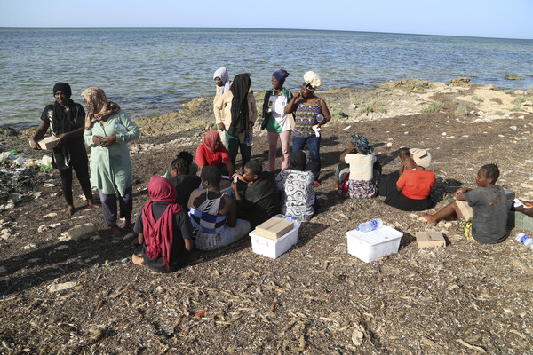 리비아와 튀니지 국경 인근 지역에 모여든 난민들.리비아 안보군과 리비아 적십자사 직원들이 식량을 나눠주고 있다.  2023. 07. 23. AP 연합뉴스
