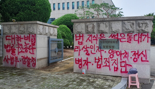 경남 밀양경찰서는 검찰청 정문을 훼손한 혐의(공용물건손상)로 A씨를 검찰에 구속 송치했다고 19일 밝혔다. 사진은 A씨가 창원지검 밀양지청 정문에 쓴 비난 글. 2023.7.19. 연합뉴스