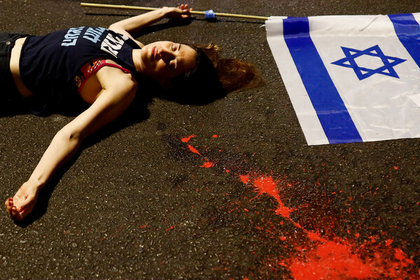 15일(현지시각) 이스라엘 텔아비브에서 한 여성이 베냐민 네타냐후 총리 연정의 사법 개혁에 반대하며 바닥에 누워 시위를 펼치고 있다. 지난 11일 이스라엘 크네세트(의회)는 사실상 유일하게 정부를 견제하는 권력인 사법부의 권한을 대폭 한정하는 정부 발의 기본법을 처리했다. 2023.07.17. 로이터 연합뉴스