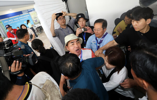 6일 새만금 세계 스카우트 잼버리 프레스센터에서 전북 연맹 지도자가 "여성 샤워장 침입 사건에 조치가 충분치 않았다"면서 항의한 뒤 경찰과 조직위 관계자들에 의해 끌려 나가고 있다. 2023.8.6. 연합뉴스 