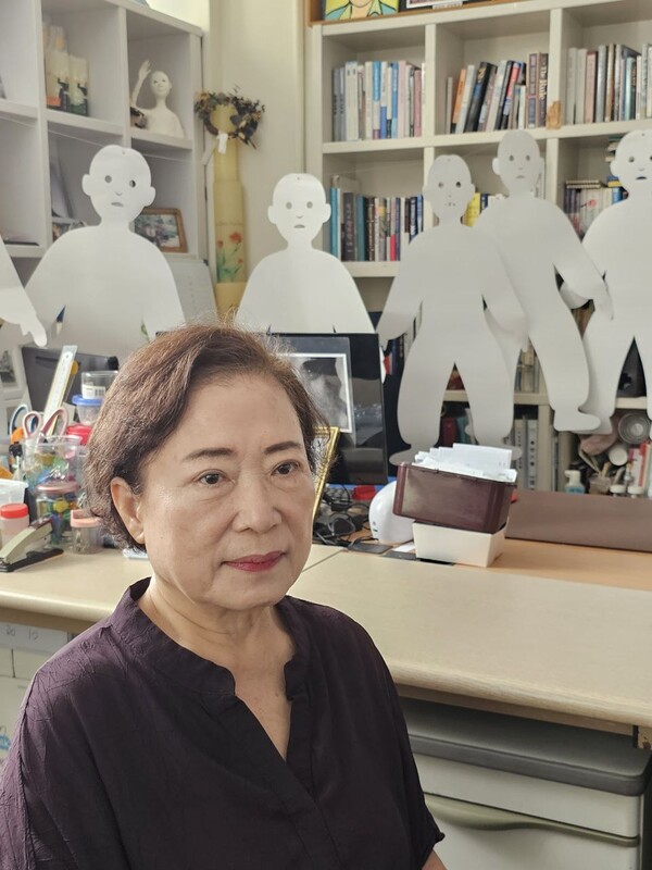 넋전들을 배경삼아 앉은 함인숙 목사.