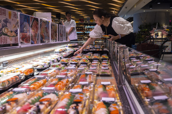 지난 12일 홍콩 가게의 일본산 수산식품 수입 코너에서 물건을 고르고 있는 고객. 18일 홍콩의 한 고위관리는 일본정부가 후쿠시마 핵오염수 해양 투기를 강행할 경우 홍콩은 일본산 수산물 수입을 즉각 중단할 것이라는 방침을 재확인했다. 2023.07.12. [AP 연합뉴스 ]