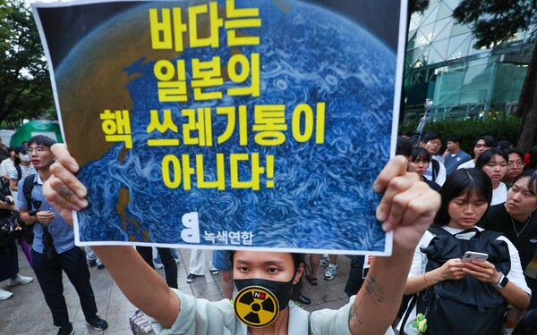 22일 오후 서울시청 앞에서 예정된 일본 원전오염수 해양투기 규탄 집회 참가자가 무대 설치를 두고 참가자와 경찰들이 충돌한 상황에서 일본 오염수 방류 규탄 피켓을 들고 있다.2023.8.22. 연합뉴스