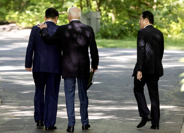 조 바이든 미국 대통령이 18일 캠프 데이비드에서 한미일 정상의 공동기자회견을 마친 뒤 산책로를 걸어가면서 윤석열 대통령의 어깨에 손을 올리고 있다. 바이든은 산책 도중 가운데에서 걸으면서 기시다 후미오 일본 총리와 윤 대통령의 어깨에 번갈아 손을 올렸다. 등에 손을 대기도 했다. 2023.8.18. EPA 연합뉴스 