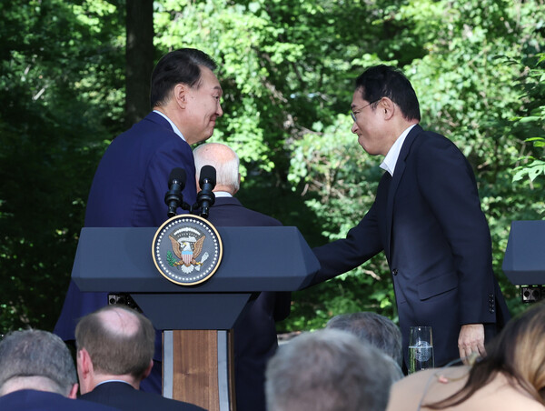 윤석열 대통령과 기시다 후미오 일본 총리가 18일(현지시간) 워싱턴DC 인근 미국 대통령 별장인 캠프 데이비드에서 한미일 정상 공동기자회견을 마친 뒤 악수하고 있다. 가운데는 조 바이든 미국 대통령. 2023.8.20. 연합뉴스