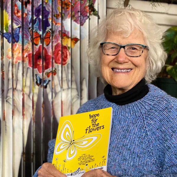 트리나 폴러스 여사가 자신이 쓴 '꽃들에게 희망을'을 들고 미소짓고 있다.  트리나 폴러스 페이스북