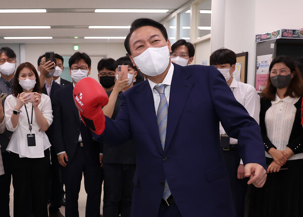 윤석열 대통령이 26일 오전 세종시 정부세종청사에서 열린 국무회의를 마친 뒤 직원들을 격려하기 위해 사무실을 둘러보다 직원으로부터 선물받은 글러브를 끼고 '어퍼컷 세리머니'를 하고 있다. 2022.5.26. 연합뉴스