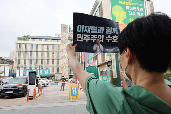 19일 오전 이재명 더불어민주당 대표가 병상 단식을 이어가고 있는 서울 중랑구 녹색병원 앞에서 한 지지자가 손팻말을 들고 있다. 2023.9.19. 연합뉴스