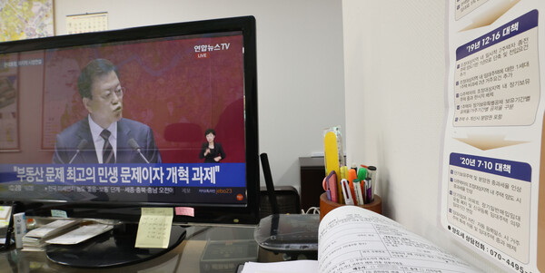  2021년 10월 25일 오전 서울의 한 부동산 중개업소에 문재인 대통령의 2022년도 예산안 시정연설 생중계가 틀어져 있다. 옆에는 양도소득세 법령적용 가이드맵이 붙어 있다. 2021.10.25 연합뉴스