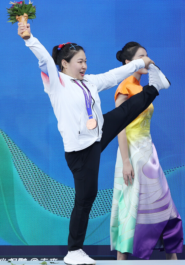 5일 중국 항저우 샤오산 스포츠센터에서 열린 2022 항저우 아시안게임 역도 여자 76kg급 그룹 A 경기에서 동메달을 차지한 김수현 선수가 시상대 위에서 왼발을 번쩍들면서 자축하고 있다. 2023.10.5. 연합뉴스 