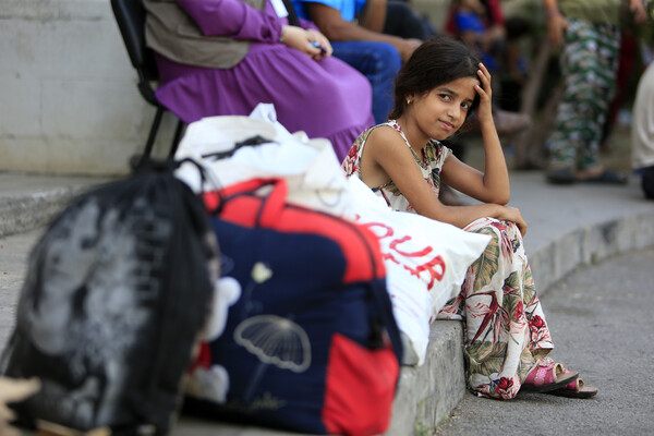 지난 9월 13일 레바논 시돈의 팔레스타인 난민캠프에서 쫓겨난 한 소녀가 다른 캠프로 이송을 기다리며 길가에 앉아 있다. 난민촌에서 나고 자란 탓인지 표정이 해맑다. 2023.9.13. AP 연합뉴스 