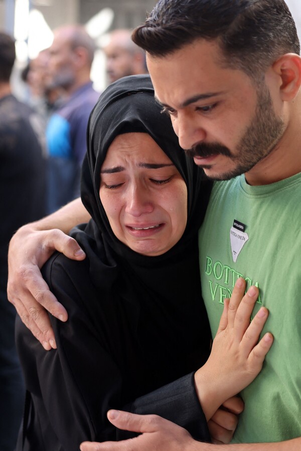 팔레스타인 가자 남부의 라파 지역에 대한 이스라엘의 폭격으로 숨진 가족의 시신을 본 여인이 흐느끼고 있다. 2023 10.21 [AFP=연합뉴스]