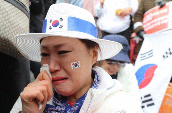 박근혜 전 대통령 1심 선고일이었던 지난 2018년 4월 6일 서울 서초구 서울중앙지법 앞에서 박 전 대통령의 지지자가 선고 결과를 확인한 뒤 눈물을 흘리고 있다. 서울중앙지법 형사합의22부(김세윤 부장판사)는 박 전 대통령의 공소사실 18가지 가운데 16가지를 유죄로 인정하고 징역 24년에 벌금 180억원을 선고했다. 2018.4.6. 연합뉴스