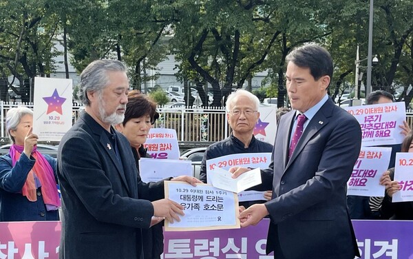 10·29 이태원 참사 유가족협의회 이정민 운영위원장(왼쪽)은 18일 서울 용산구 대통령실 앞에서 기자회견을 열고 이태원 참사 1주기 추모대회에 윤석열 대통령을 초청한다고 밝혔다. 사진은 대통령실 시민사회수석실 신진영 행정관(오른쪽)이 이정민 위원장으로부터 초청장을 받고 있는 모습. 2023.10.18. 김성진 기자