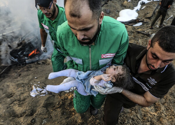 팔레스타인 주민들이 가자시티에 대한 이스라엘의 공습으로 파괴된 돌더미에 파묻혀 부상당한 한 여아를 옮기고 있다. 2023. 10. 25 [EPA=연합뉴스]