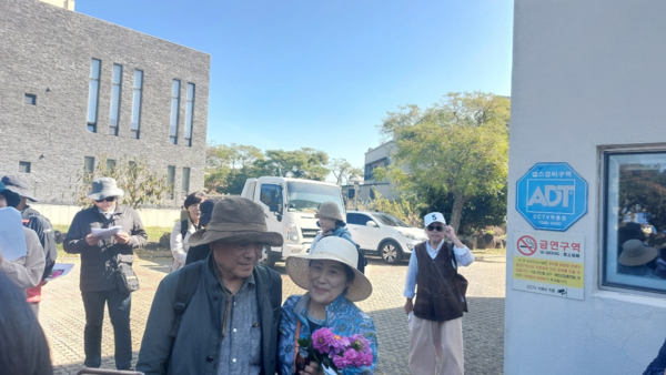 이덕구 무장대장의 종손녀(오른쪽)가 답사에 참여해 조천중학원 터에서 증언을 한 뒤 현기영 작가와 기념사진을 찍고 있다. © 이봉수