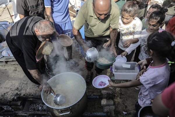 지난 25일 가자지구 남부 칸유니스의 팔레스타인난민구호기구(UNRWA) 천막촌으로 피난한 가자주민들이 팔레스타인 자원봉사자들이 마련한 음식을 배급받기 위해 줄을 서서 기다리고 있다. 2023..10.25. EPA 연합뉴스