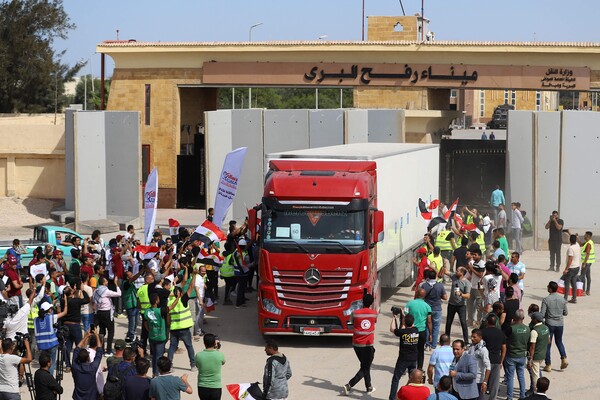 이집트 적신월사 직원들이 21일 라파 통로에서 가자주민을 위한 구호 물품을 실은 트럭이 통과하게 된 것을 기뻐하고 있다. 2023ㅣ.10.21. AFP 연합뉴스 