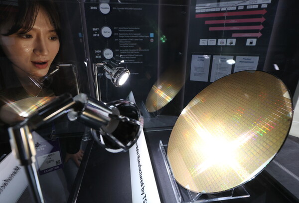 지난달 25일 서울 강남구 코엑스에서 열린 반도체대전(SEDEX)의 한 부스에서 관계자가 웨이퍼를 살펴보고 있다. 2023.10.25. 연합뉴스