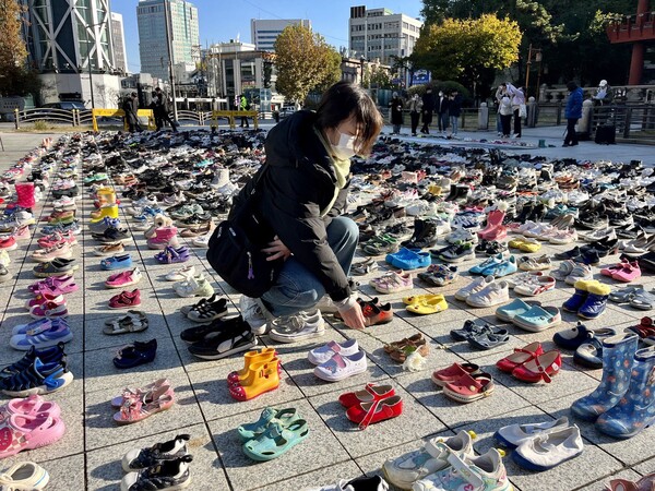'팔레스타인과 연대하는 한국 시민사회 긴급행동'은 17일 오전 서울 종로구 보신각 앞 광장에서 '모든 희생자를 애도하는 신발들의 시위'를 열고, 신발 2000켤레를 설치했다. 신발은 이스라엘의 가자지구 공습과 폭격에 의해 희생된 팔레스타인인들을 상징한다. 시민 활동가가 신발 위에 국화를 헌화하는 모습. 2023.11.17. 김성진 기자