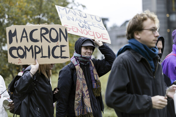 에마뉘엘 마크롱 프랑스 대통령이 스위스를 국반방문한 가운데 16일 로잔대학에서 마크롱의 방문에 반대하는 시위를 벌이고 있다. 한 피켓에는 "마크롱 공범"이라고 씌어 있다 2023. 11.16 [AP=연합뉴스]