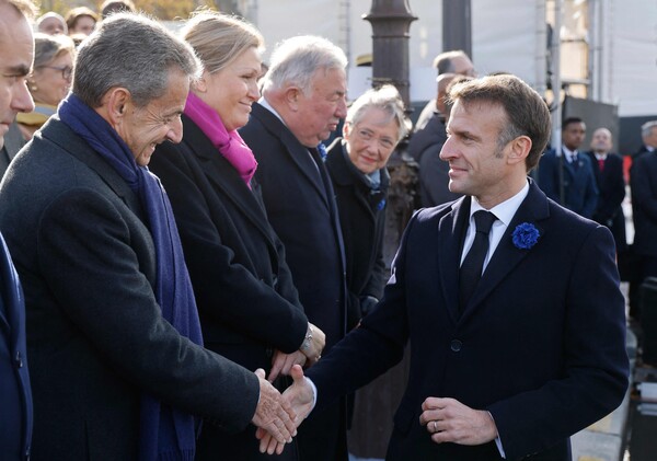 에마뉘엘 마크롱 프랑스 대통령(오른쪽)이 11일 파리의 아크 드 트리옹프에 있는 무명용사묘에서 열린 행사에 참석해  니콜라 사르코지 전 대통령(왼쪽)과 악수하고 있다. 2023, 11. 11 [AFP=연합뉴스]