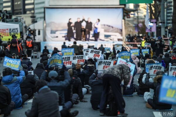 25일 서울 지하철 시청역 앞에서 열린 66차 촛불대행진에 참가한 시민들이 구호를 외치고 있다. 연단에는 문재인 대통령과 김정은 국무위원장이 지난 2018년 9월 20일 오전 백두산 장군봉에서 손을 맞잡은 사진을 걸었다. 2023.11.25. 사진 이호 작가