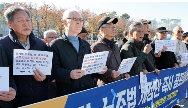 지난 11월 21일 서울 용산구 전쟁기념관 앞에서 열린 '노란봉투법 시행을 요구하는 사회원로 기자회견'에 참석한 인사들이 손팻말을 들고 있다. 연합뉴스