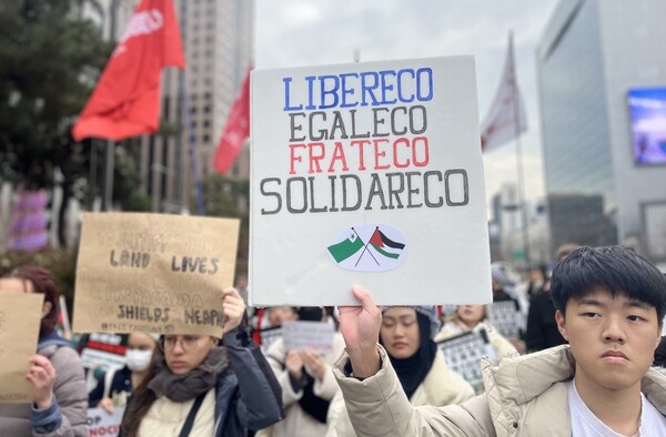 26일 '이스라엘의 가자지구 공격 규탄 한국 시민사회 3차 긴급행동' 집회에 참가한 시민들이 광화문 사거리 인근을 행진하며 구호를 외치고 있다. 한 시민이 에스페란토어로 '자유, 평등, 박애, 연대'라고 적힌 팻말을 들어보이고 있다. 2023.11.26. 김성진 기자