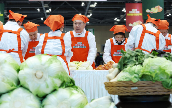 윤석열 대통령과 부인 김건희 씨가 27일 경기 고양 일산 킨텍스에서 열린 '나눔과 봉사의 국민 대통합 김장행사'에서 김치를 담그고 있다. 2023.11.27 [대통령실통신사진기자단] 연합뉴스