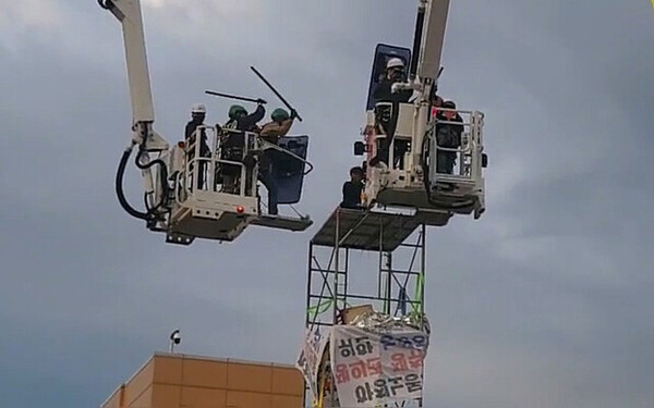 지난 5월 31일 새벽 전남 광양시 포스코 광양제철소 앞 고공농성장에서 경찰과 소방대원이 농성하던 한국노총 금속노련 간부를 진압봉으로 제압하고 있다. 2023. 5. 31. 한국노총 동영상 갈무리