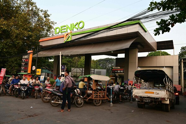 6일(현지시간) 미얀마 양곤 주민들이 차량과 오토바이에 석유를 채워 넣기 위해 주유소에서 길게 줄을 서고 있다. 현지 국영 매체들은 이날 새벽부터 양곤 주유소에는 차량 수백 대가 줄을 섰다고 전했다. 2023.12.6. AFP 연합뉴스