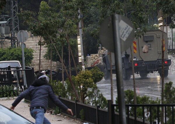 한 팔레스타인 남성이 7일 요르단강 서안 도시인 나블루스를 급습한 이스라엘군을 향해 돌을 던지고 있다. 팔레스타인 보건부에 따르면, 이날 이스라엘군의 습격에 따른 충돌로 최소 3명의 팔레스타인인이 다쳤다. 2023 12. 07 [EPA=연합뉴스]
