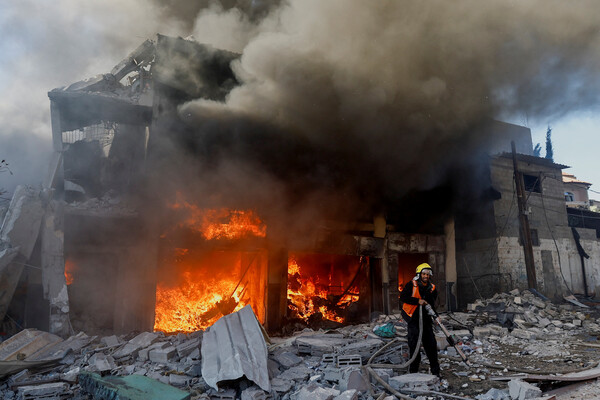 가자지구 남부의 칸 유니스에서 한 팔레스타인 소방대원이 이스라엘의 폭격으로 인한 불을 끄고 있다.  2023. 12. 09 [로이터=연합뉴스]