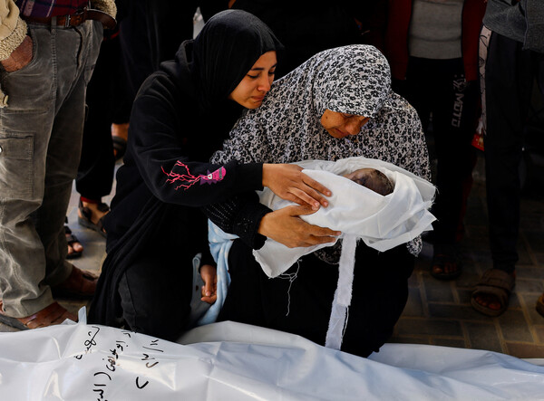 남부 가자의 라파 소재 아부 유세프 알-나자르 병원에서 한 할머니가  아기 손주의 주검을 안고 있다.  갓 태어난 이 아기는 이스라엘의 공격을 받고 세상을 떠났다.  2023 12.12 [로이터=연합뉴스]