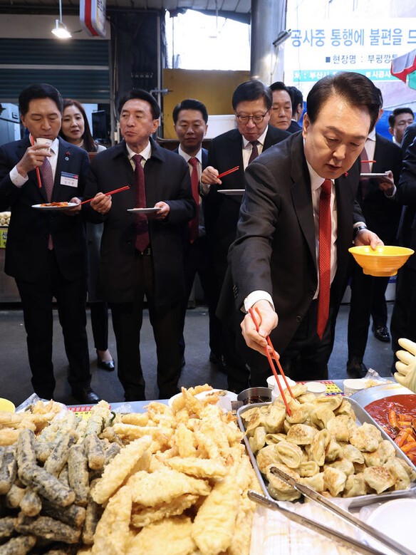 윤석열 대통령이 지난 6일 부산 중구 깡통시장을 방문해 젓가락으로 만두를 뒤적거리고 있다. 대통령실통신사진기자단. 2023. 12. 6. 연합뉴스  