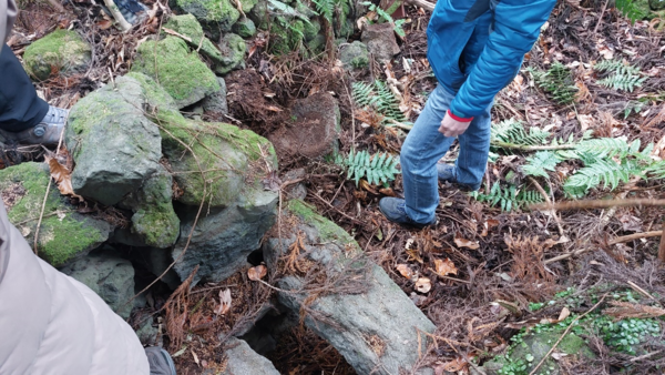 섯단마을 폐허에 돼지를 키우는 ‘돗통시’가 원형 그대로 남아 있다. 사진 아래쪽에 사람이 걸터앉아 용변을 보는 통시가 있고, 가운데 서 있는 사람 발 앞쪽에 돌절구처럼 생긴 것이 돼지에게 먹이를 주는 ‘돗도고리’이다. © 이봉수