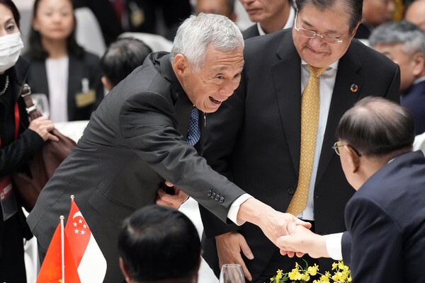  18일 도쿄에서 열린 일본-ASEAN 특별정상회의에 참석한 리센룽 싱가포르 총리가 참석자들과 악수를 나누고 있다. 2023.12.18. AP 연합뉴스