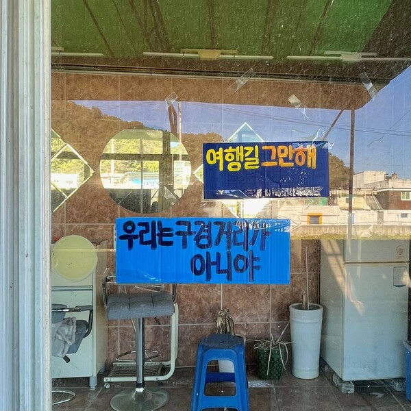 집결지 내 유리벽에 '여행길' 행사를 멈추라는 문구가 적힌 피켓이 붙어있다. ©나혜, 무단전재 및 재배포 금지