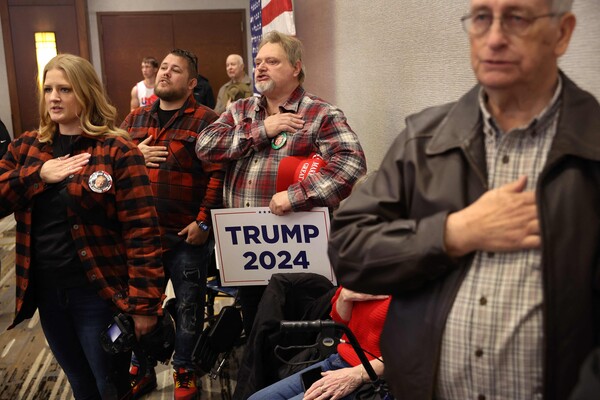 도널드 트럼프 전 미국 대통령을 지지하는 아이오와주 코럴빌 시민들이 13일(현지시간) 이곳 하얏트호텔에서 트럼프가 주최한 행사에 참석해 국기에 대한 맹세를 하고 있다. 아이오와주 공화당원들은 내년 1월 15일 코커스에서 다른 주들보다 먼저 공화당 후보를 선출한다. 2023.12.14. AFP 연합뉴스