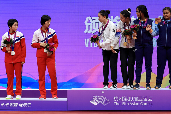 지난 2일 중국 항저우 궁수 캐널 스포츠파크 체육관에서 열린 항저우 아시안게임 탁구 여자 복식 결승전에서 금메달을 받은 남측 신유빈-전지희가 은메달을 딴 북측 차수영-박수경에게 함께 사진을 찍자고 권하고 있다. 2023. 10. 2. 로이터 연합뉴스 