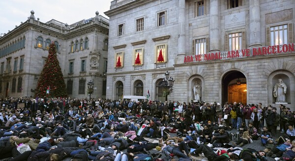 스페인 바르셀로나의 한 광장에서 팔레스타인을 지지하는 시위대가 예수의 성탄화(뒷편) 앞에서 죽은 체 하고 있다. 2023. 12. 29 [EPA=연합뉴스]