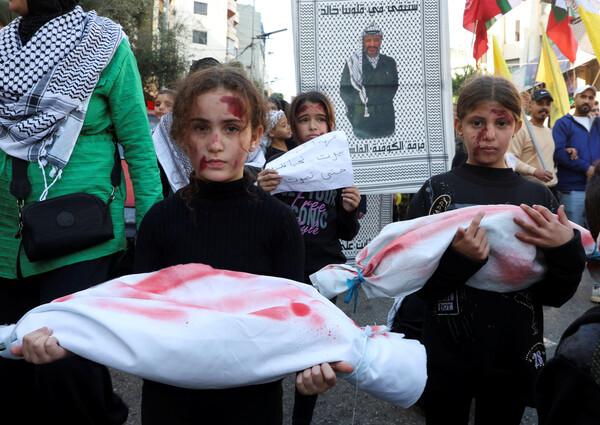 '7일 팔레스타인 순교자의 날'을 기념해 가자에서 팔레스타인 지지 시위 도중  어린인들이 모형 주검들을 들고 행진하고 있다. 2024. 01. 07 [로이터=연합뉴스]